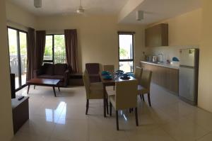 a kitchen and living room with a table and chairs at Cozy Swiss Garden Beach Resort Residence in Kampung Sungai Karang
