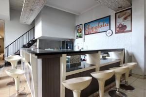 eine Bar in einem Restaurant mit Barhockern um einen Tresen in der Unterkunft RedDoorz near Adisucipto Airport 3 in Yogyakarta