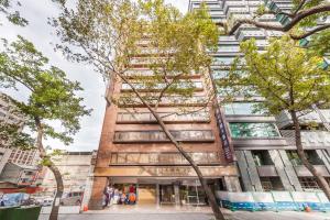 un edificio alto con árboles delante de él en Green World Sansui, en Taipéi