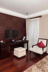 a living room with a tv and a couch and a chair at Arunreas Hotel in Phnom Penh