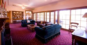 uma sala de estar com sofás, cadeiras e janelas em Ranelagh House em Dubbo