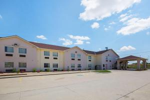 a large white building with a parking lot at Motel 6 Omaha - IAT West in Omaha