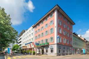 温特图尔Hotel Wartmann am Bahnhof的城市街道上的一栋红色高楼