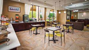 a restaurant with tables and chairs and a counter at Best Western Inn & Suites Monroe in Monroe