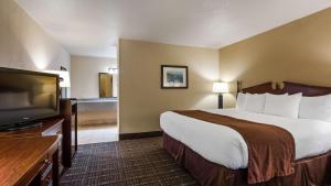 a hotel room with a bed and a flat screen tv at Best Western Lakewood- Historic Landmark in Lakewood