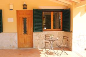 a table and chairs in front of a house with a door at Finca Verde in Llucmajor