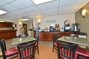 a restaurant with tables and chairs and a counter at Super 8 by Wyndham Bridgeview/Chicago Area in Bridgeview