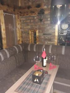 a living room with a couch and a table with wine glasses at Apartments Artic in Jahorina