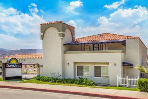 una gran casa blanca al lado de una calle en Days Inn by Wyndham Banning Casino/Outlet Mall, en Banning