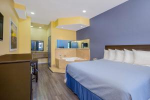 a hotel room with a bed and a bathroom at Days Inn by Wyndham Banning Casino/Outlet Mall in Banning
