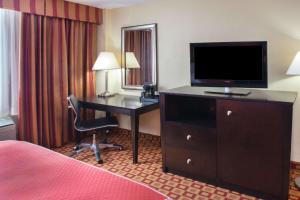 a hotel room with a desk and a television at Super 8 by Wyndham Chicago Northlake O'Hare South in Northlake