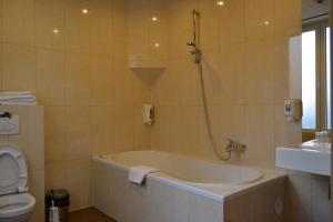a bathroom with a bath tub and a toilet at Hotel Albert II Oostende in Ostend +37 photos