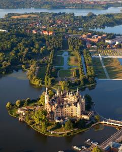 eine Luftansicht einer Burg auf einer Insel im Wasser in der Unterkunft Boulevard Hotel Altstadt Schwerin in Schwerin