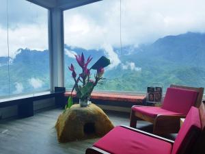 a room with a large window with a vase with flowers at Phuong Nam Hotel in Sapa