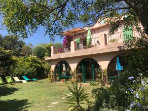 a house with a balcony and chairs in the yard at La Bastide Dambrine in Sanary-sur-Mer