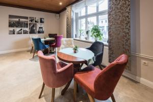 a room with chairs and a table and a window at Novel Hotel in Wusterhausen