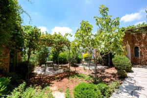 a garden with trees and a brick building at Tur Sinai Organic Farm Resort in Jerusalem