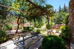 a wooden picnic table in a garden with trees at Tur Sinai Organic Farm Resort in Jerusalem
