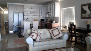 Il comprend un salon avec un canapé et une cuisine. dans l'établissement Point Village Accommodation - Beach Club 307, à Mossel Bay