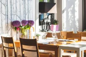 a dining room with a wooden table with chairs and flowers at Landhotel & Restaurant Walsers in Efringen-Kirchen