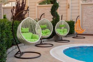 a group of swinging chairs next to a pool at DiliMah Premium Luxury in Samarkand +102 photos