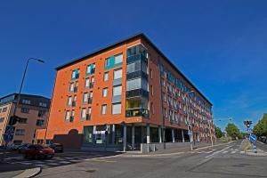 a red brick building on a street corner with a street at Pro Apartments 5 in Vaasa