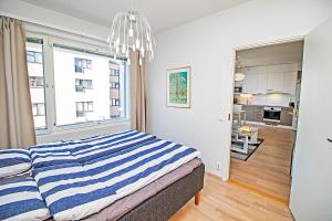 a bedroom with a blue and white striped bed at Pro Apartments 5 in Vaasa