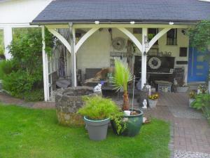 a screened in porch of a house with potted plants at Villa Jani b&b in Breitscheid