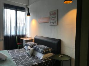 Schlafzimmer mit einem Bett mit Kissen und einem Tisch in der Unterkunft Check In Lodge in Kuching
