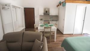 Il comprend un petit salon avec une table et une cuisine. dans l'établissement Casa Rosalba, à Grottaglie