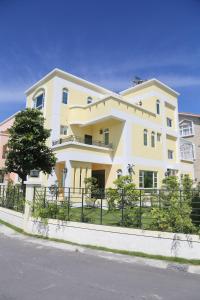 ein großes gelbes Haus mit einem Zaun davor in der Unterkunft Taitung Holidays B&B in Taitung