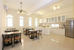 eine Küche mit Tischen und Stühlen sowie einem Kühlschrank in der Unterkunft Taitung Holidays B&B in Taitung