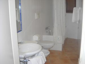 a white bathroom with a toilet and a sink at Hotel Club San Diego in Maratea