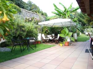 un patio con mesa y sombrilla en Casa Nueva Carmen, en Pendueles