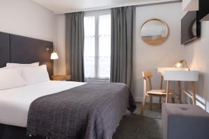 una habitación de hotel con una cama y un escritorio en Hotel d'Espagne, en París