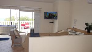 a living room with a couch and a tv on the wall at Bayview in Durban