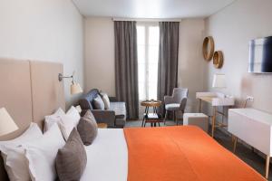 パリにあるホテル デエスパーニュのベッドとリビングルームが備わるホテルルームです。