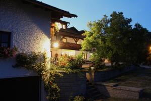 a house with a brick wall and a tree at Pension Zum Ebenstein am Donausteig in Untergriesbach