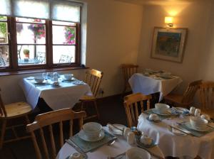 a dining room with two tables with white table cloth at The Talbot Inn in Much Wenlock