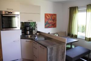 a kitchen with a white refrigerator and a sink at Ferienwohnung Melanie in Hart im Zillertal