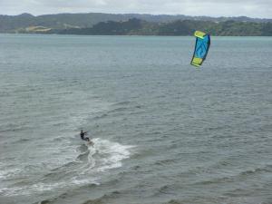 una persona es kite surf en el agua en Harbourside Getaway, en One Tree Point