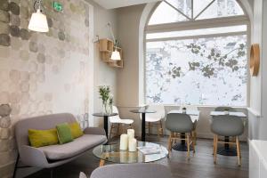 Una sala de estar con una silla y una mesa. en Hotel d'Espagne, en París