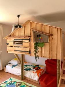 a loft bed with a microwave and a bed in a room at Chambres d'Hôtes La Téouleyre in Saint-Julien-en-Born
