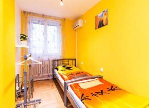 a bedroom with two beds in a yellow room at CentralComfortBDPST in Budapest