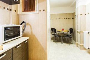 a kitchen with a microwave and a table with chairs at CentralComfortBDPST in Budapest