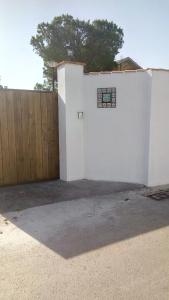 a white wall with a gate and a fence at El vivero in Chiclana de la Frontera