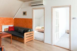 a living room with a couch and a mirror at Masi Felső Apartman in Pécs