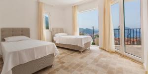 a bedroom with two beds and a large window at Villa Yagmur in Kalkan +33 photos