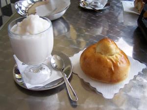 a table with a glass of milk and a bagel and a drink at Sikania Casa Diamond in Messina