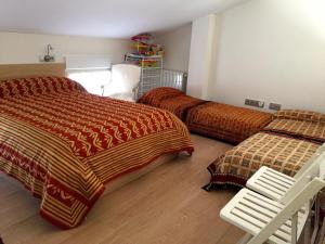 a bedroom with two beds and a white chair at El Corral De La Simona in Villalmanzo